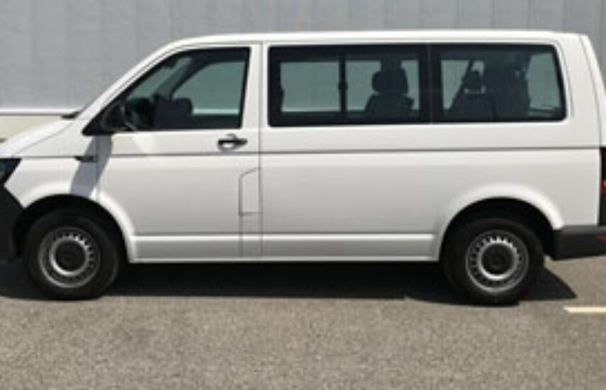 Boční pohled na bílý mikrobus Volkswagen Transporter